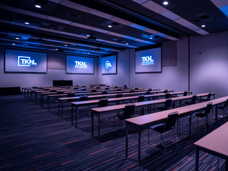 A room equipped with motorized screens, tables and chairs