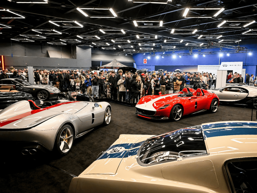 Salon de l'Auto avec 3 voitures en premier plan et une foule en arrière. 