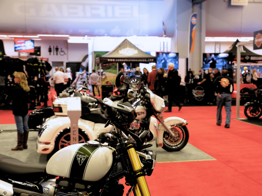 3 vélos et des personnes derrière pendant le salon de la moto