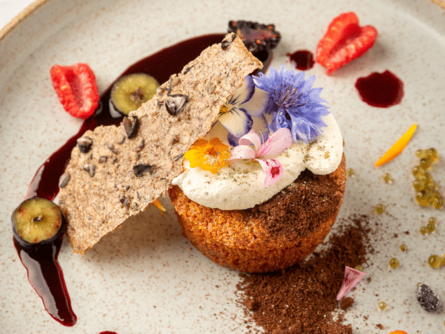 Un dessert avec des fruits sur une assiette de couleur crème.