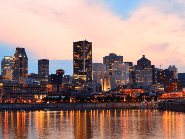 Montréal sur le fleuve au coucher du soleil avec les lumières de la ville et les bâtiments urbains