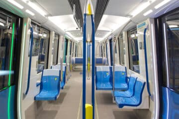 Intérieur du métro de Montréal vide, sièges bleus et sol gris.